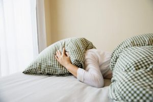 lady-cover-her-head-by-pillow-bed