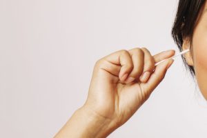 woman-cleaning-her-ears-with-cotton-swabs