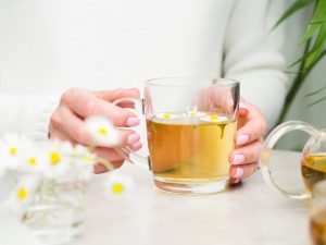 front-view-woman-holding-tea-glass_23-2148567593