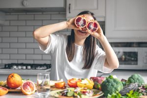 funny-young-woman-with-orange-halves-kitchen_169016-29797