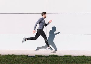 handsome-man-leaping-near-white-wall_23-2147755405